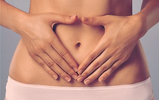 Síndrome do Ovário Policístico, imagem de mulher sem blusa com as mãos postas na barriga formando um coração ao redor do umbigo.